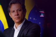 Homem de terno e camisa branca, olhando à frente. Bandeira do Brasil ao fundo.