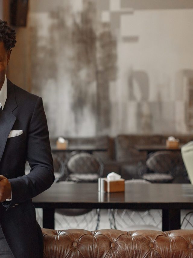 Black man in a black suit standing in a cafe