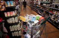 Carrinho de compras cheio de produtos 365 Whole Foods Market em corredor de supermercado.