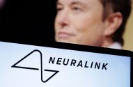 Elon Musk desfocado com o logotipo e o nome da Neuralink em uma tela em primeiro plano.