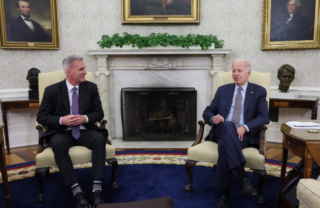 Presidente Biden e Kevin McCarthy conversam sentados no Salão Oval.