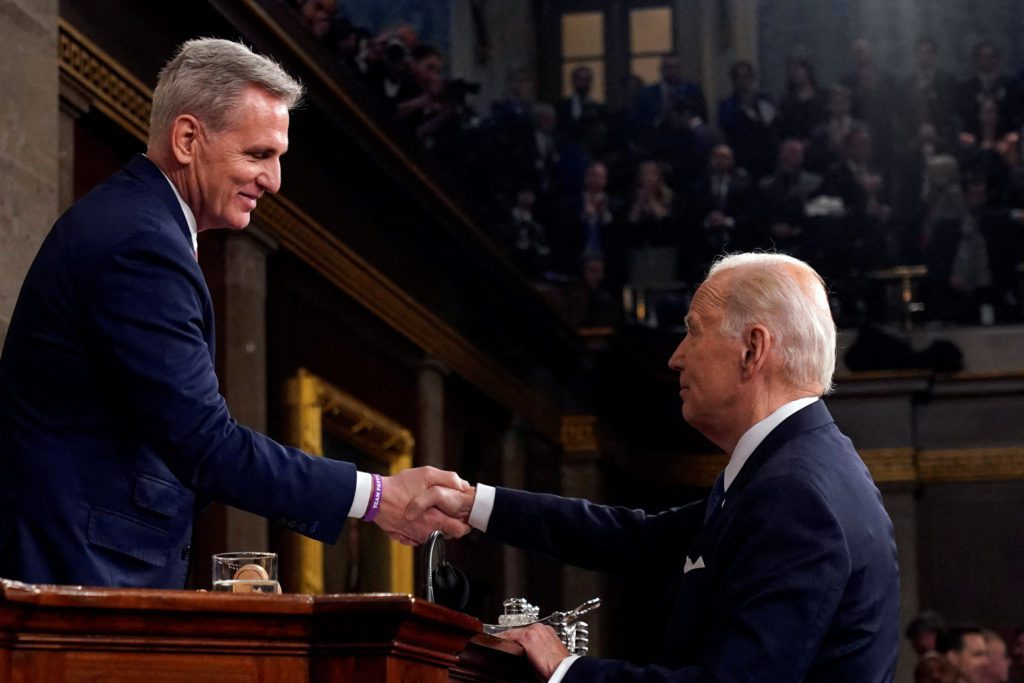 Kevin McCarthy e Joe Biden apertam as mãos.