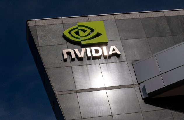O logotipo da Nvidia em verde e o nome "NVIDIA" em letras metálicas no prédio, sob um céu azul.