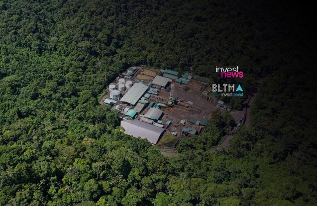 Vista aérea de complexo industrial com tanques em meio à floresta densa.