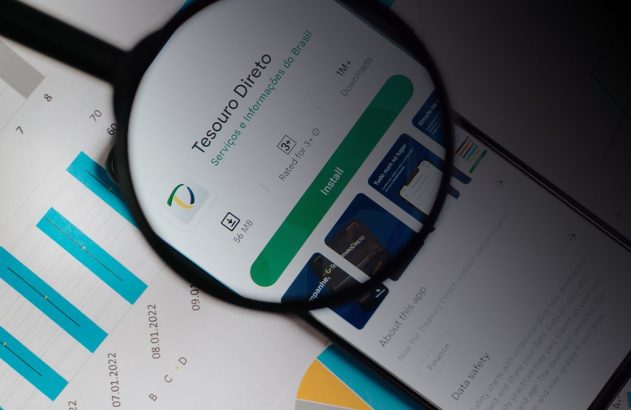 Lupa ampliando a tela de um smartphone, focando em um aplicativo.