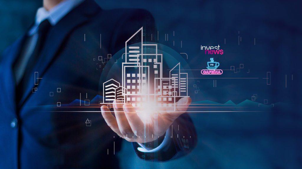 Mão apresenta projeção digital de edifícios e figuras humanas flutuando no ar.