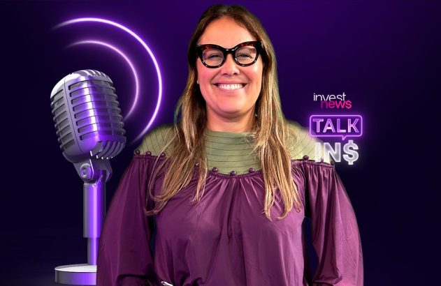 Mulher sorrindo, de óculos, posa ao lado de microfone vintage roxo, com logo "Invest News Talk IN$" neon.