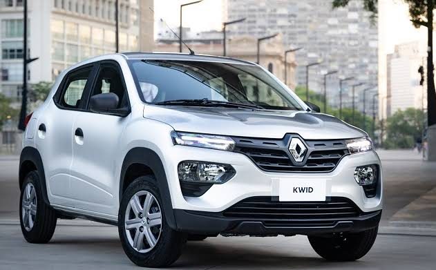 Renault Kwid branco, visão 3/4 frontal, estacionado em rua urbana sob luz do dia.