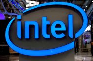 Logotipo azul e iluminado da Intel, exibido em um estande de evento.