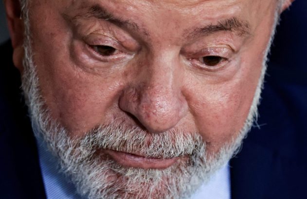 Close-up do rosto de um homem com barba grisalha, olhando para baixo.