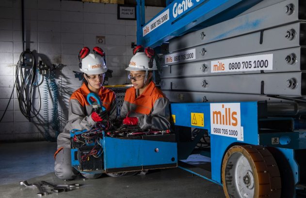 Duas pessoas com EPIs trabalhando na manutenção de uma plataforma elevatória azul da Mills.