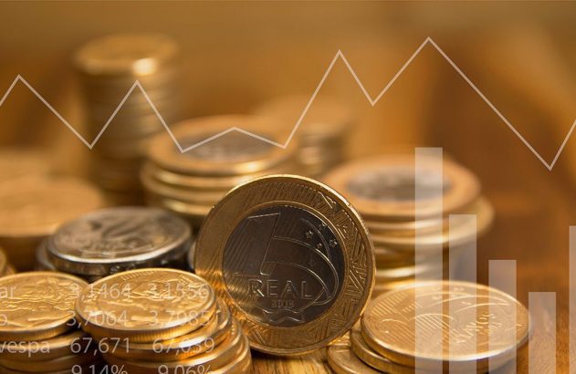 Moedas de Real com gráficos financeiros e cotações de Dólar, Euro e Ibovespa.