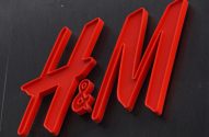 Logo vermelho 3D da H&M em fundo escuro.
