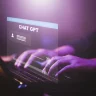 homem teclando em um notebook, com uma projeção virtual do chat gpt