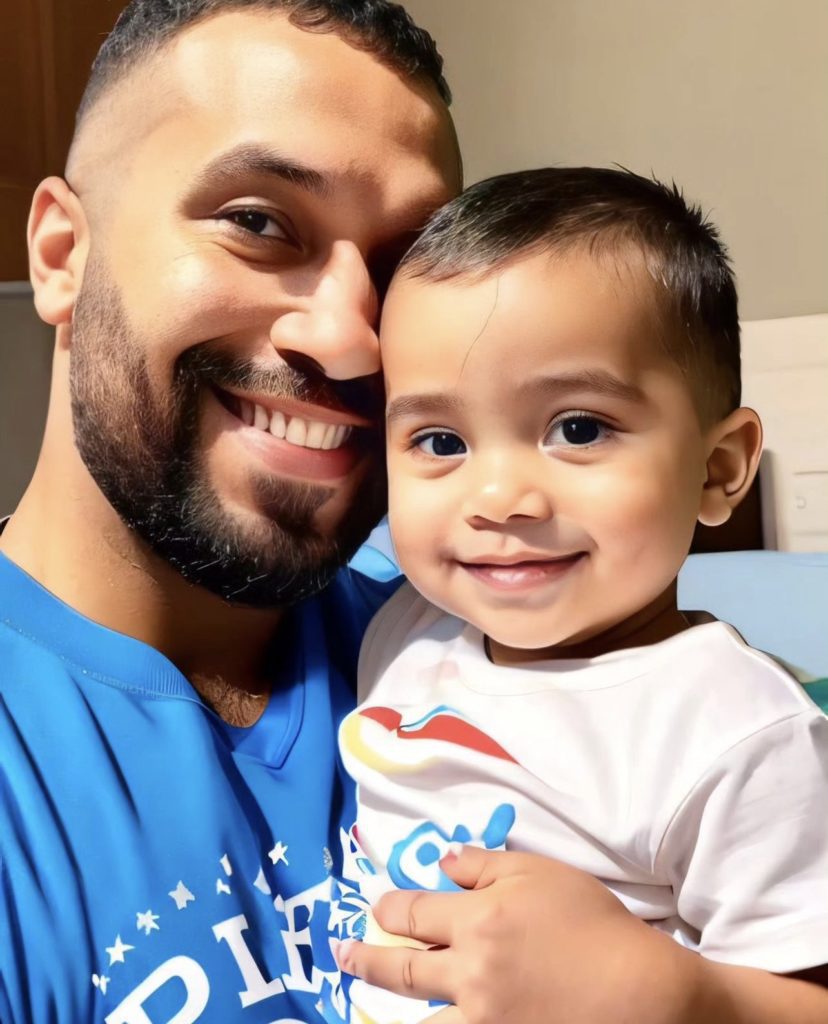 Pai e filho sorrindo para a câmera.