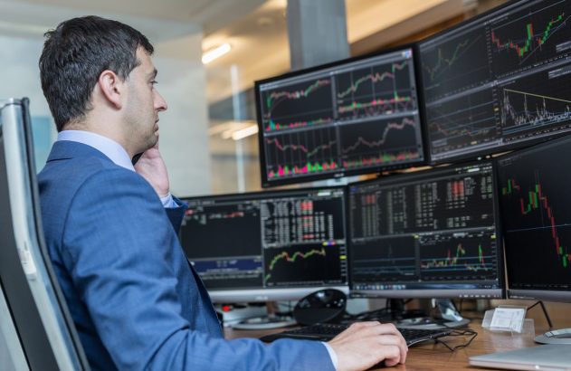 trader utilizando a estratégia de scalping em frente a diversas telas de computador, com gráficos