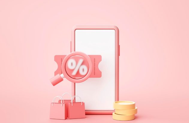 Smartphone com banner de desconto em destaque, com uma lupa à frente, acima de sacolas de compra e moedas.