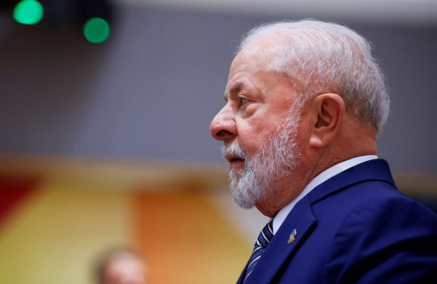 Lula, presidente do Brasil, de perfil em terno azul, com barba e cabelo brancos, olha à esquerda.