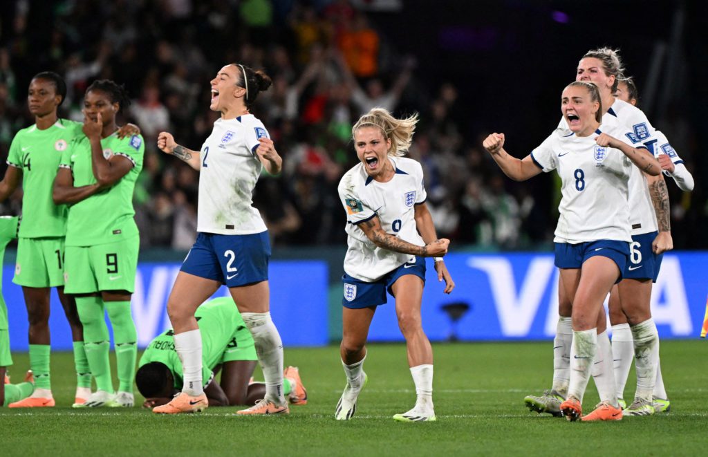 Jogadoras de branco celebram com euforia; jogadoras de verde expressam frustração no campo.