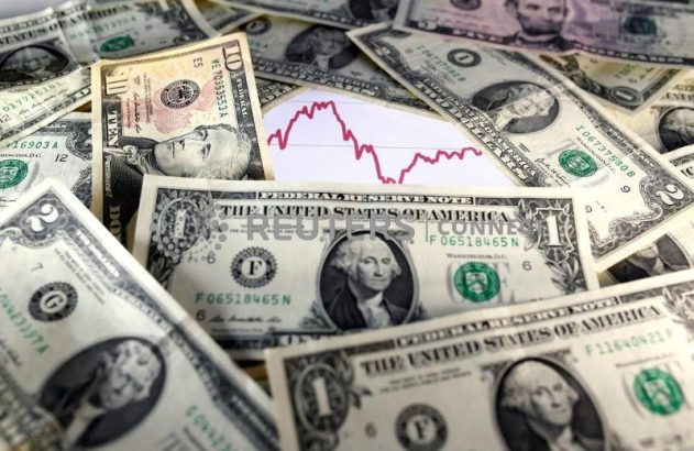 Dólares espalhados sobre gráfico de mercado financeiro em queda.