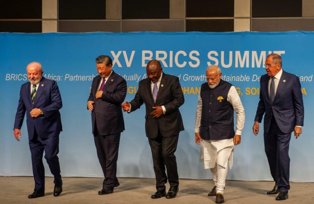 Cinco líderes do BRICS (Lula, Xi, Ramaphosa, Modi, Lavrov) sorrindo e caminhando no XV BRICS Summit.