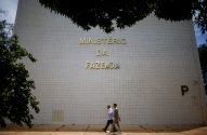 Prédio do Ministério da Fazenda. Dois homens caminham na calçada em frente.