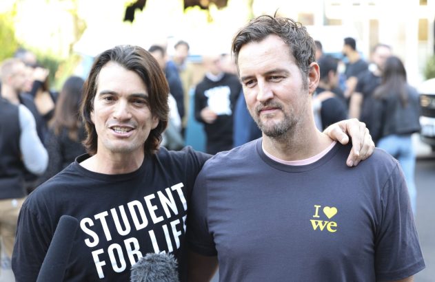 Dois homens sorrindo para a câmera. Um usa camisa "STUDENT FOR LIFE", o outro o abraça pelo ombro. Fundo com pessoas.