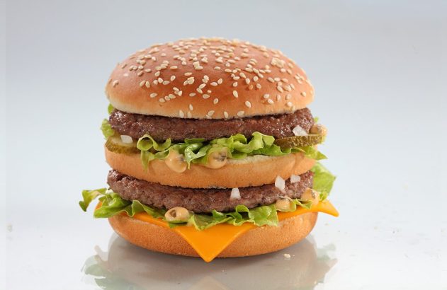 Big Mac: pães, duas carnes, queijo, alface, picles, cebola e molho especial. Fundo branco.