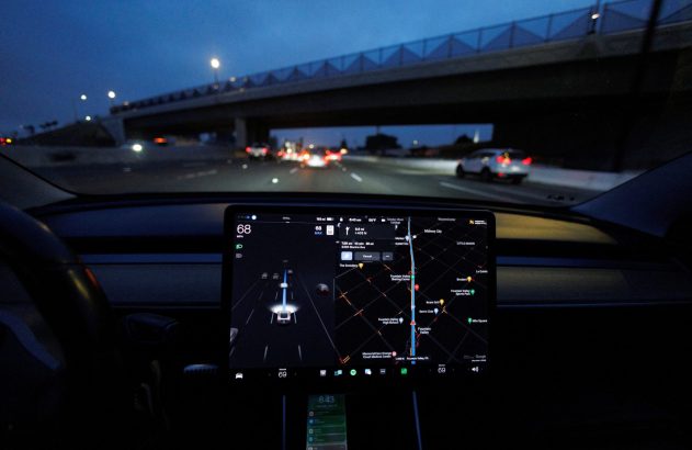 Interior de Tesla à noite, com tela exibindo navegação GPS e visualização do tráfego na autoestrada.