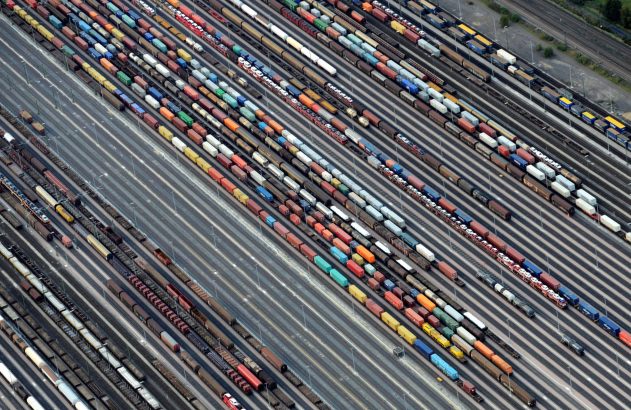 Vista aérea de pátio de manobras ferroviário, com inúmeros vagões de carga em trilhos.
