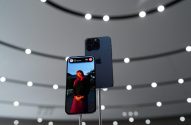 Dois iPhones azuis em exibição. Um mostra uma mulher na tela, o outro a parte traseira com as câmeras.