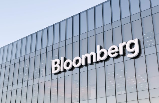 Fachada de vidro de um edifício moderno com o letreiro branco "Bloomberg".