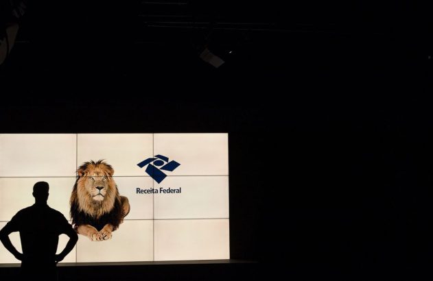 Silhueta de pessoa olhando tela com leão, "Receita Federal" e seu logo.
