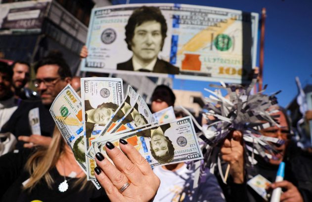 Manifestantes exibem notas de dólar com o rosto de Javier Milei e um banner similar. Uma mão segura várias notas.