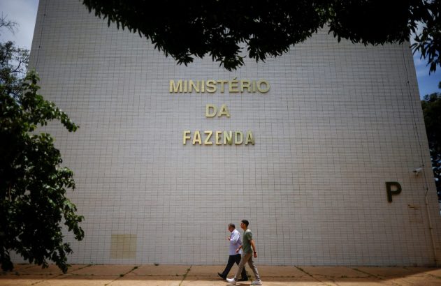 Fachada do Ministério da Fazenda, com duas pessoas caminhando em frente.