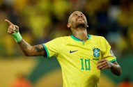 Jogador com camisa 10 do Brasil, em êxtase, apontando para cima com braço enfaixado.