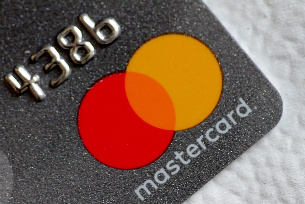 Cartão Mastercard cinza escuro com glitter, números em relevo e logo.