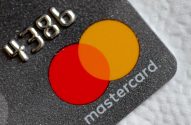 Cartão Mastercard cinza escuro com glitter, números em relevo e logo.