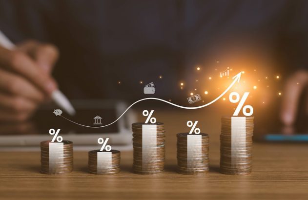 Gráfico de moedas empilhadas em ascensão com símbolos de porcentagem e seta de crescimento, pessoa calculando.