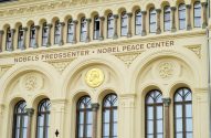 Entrada do Nobel Peace Center, com fachada creme ornada, janelas e um medalhão dourado.