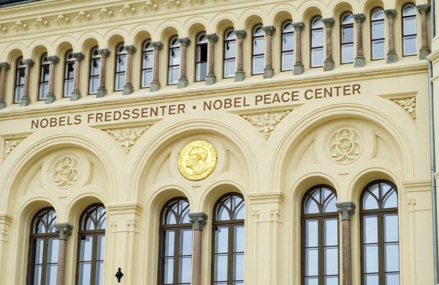 Entrada do Nobel Peace Center, com fachada creme ornada, janelas e um medalhão dourado.