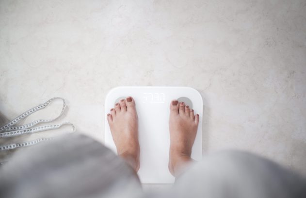 Pés descalços sobre uma balança branca.