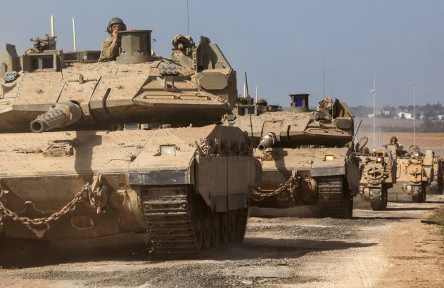Comboio de tanques e veículos blindados israelenses avançando em estrada de terra. Soldados em escotilhas.
