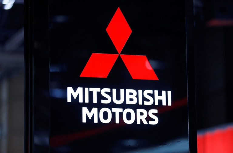 Logotipo vermelho e branco da Mitsubishi Motors em display escuro.