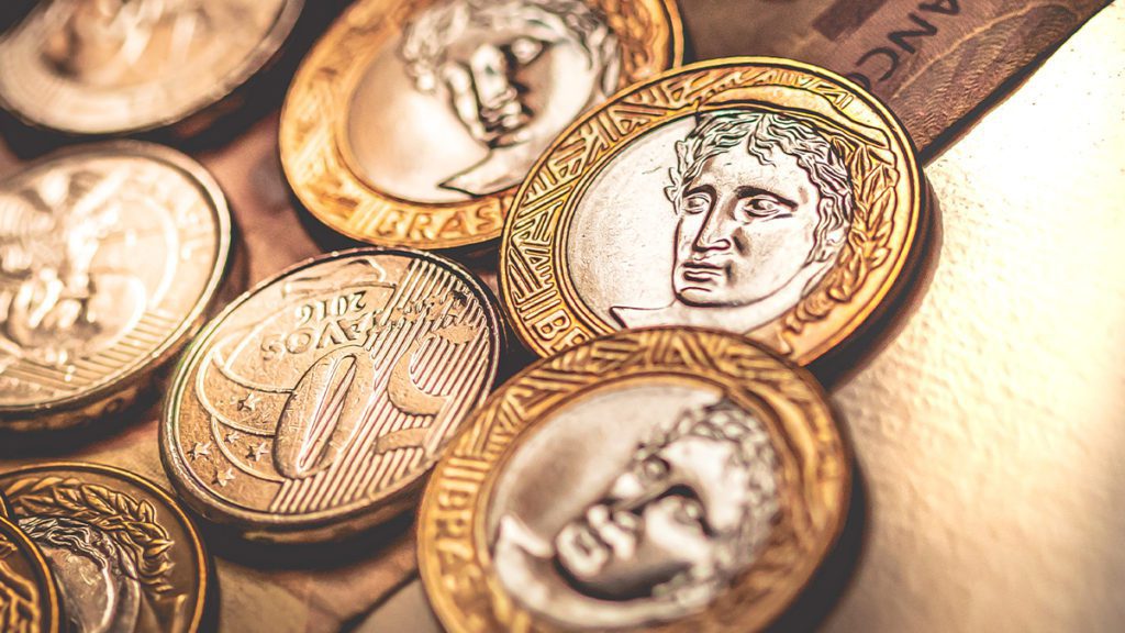 Moedas bimetálicas exibindo retratos de figuras históricas.