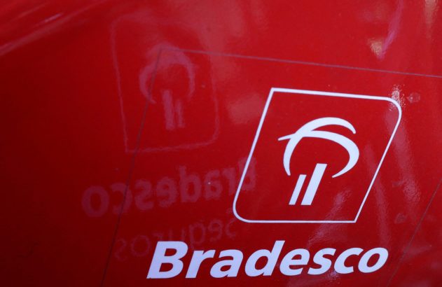 Logotipo branco Bradesco em destaque em superfície vermelha. O símbolo P estilizado e o nome são visíveis, com um leve reflexo.