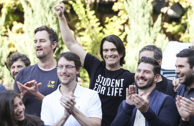 Grupo de pessoas, a maioria homens, sorrindo e aplaudindo ao ar livre. Um deles levanta o punho com camisa "STUDENT FOR LIFE".