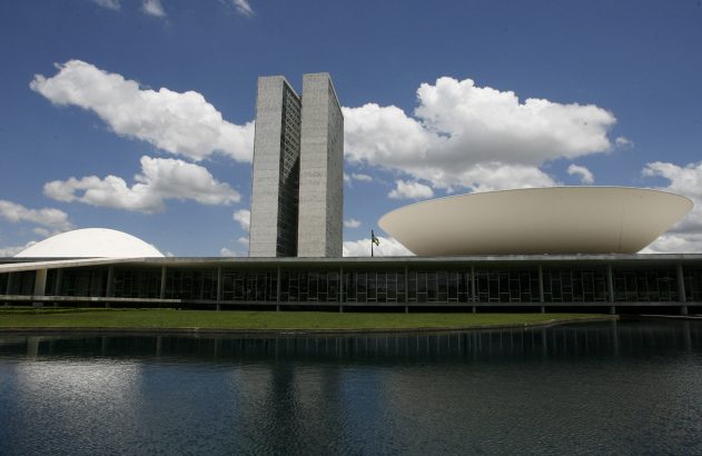 Congresso Nacional do Brasil em Brasília: torres, cúpula e tigela invertida sobre edifício, refletidos em espelho d'água.