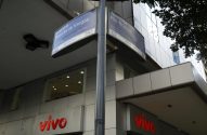 Placas de rua com "Avenida Presidente Vargas" e "Avenida Rio Branco" em cruzamento urbano com logo Vivo.
