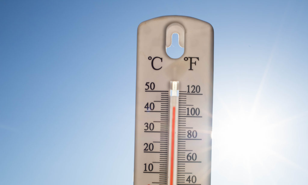 Termômetro externo marcando 40°C (104°F) sob céu azul e sol forte.